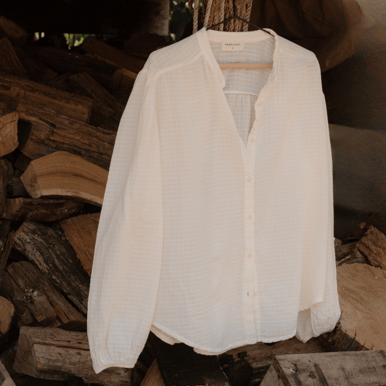 Boho Bluse Hilda, aufgehängt vor Feuerholz
