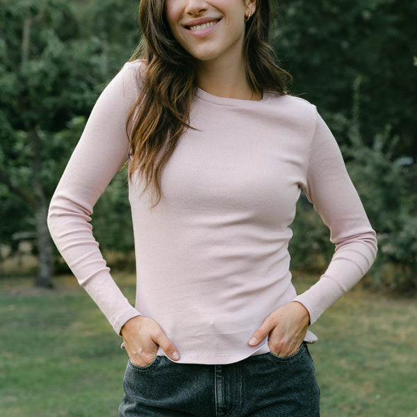 Frau trägt das Ripp Langarmshirt Lica in Rosa mit dunkelblauer Jeans im Park
