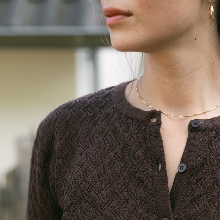 Detailaufnahme des Rundhalsausschnitts und der Knöpfe der Strickjacke Rieke